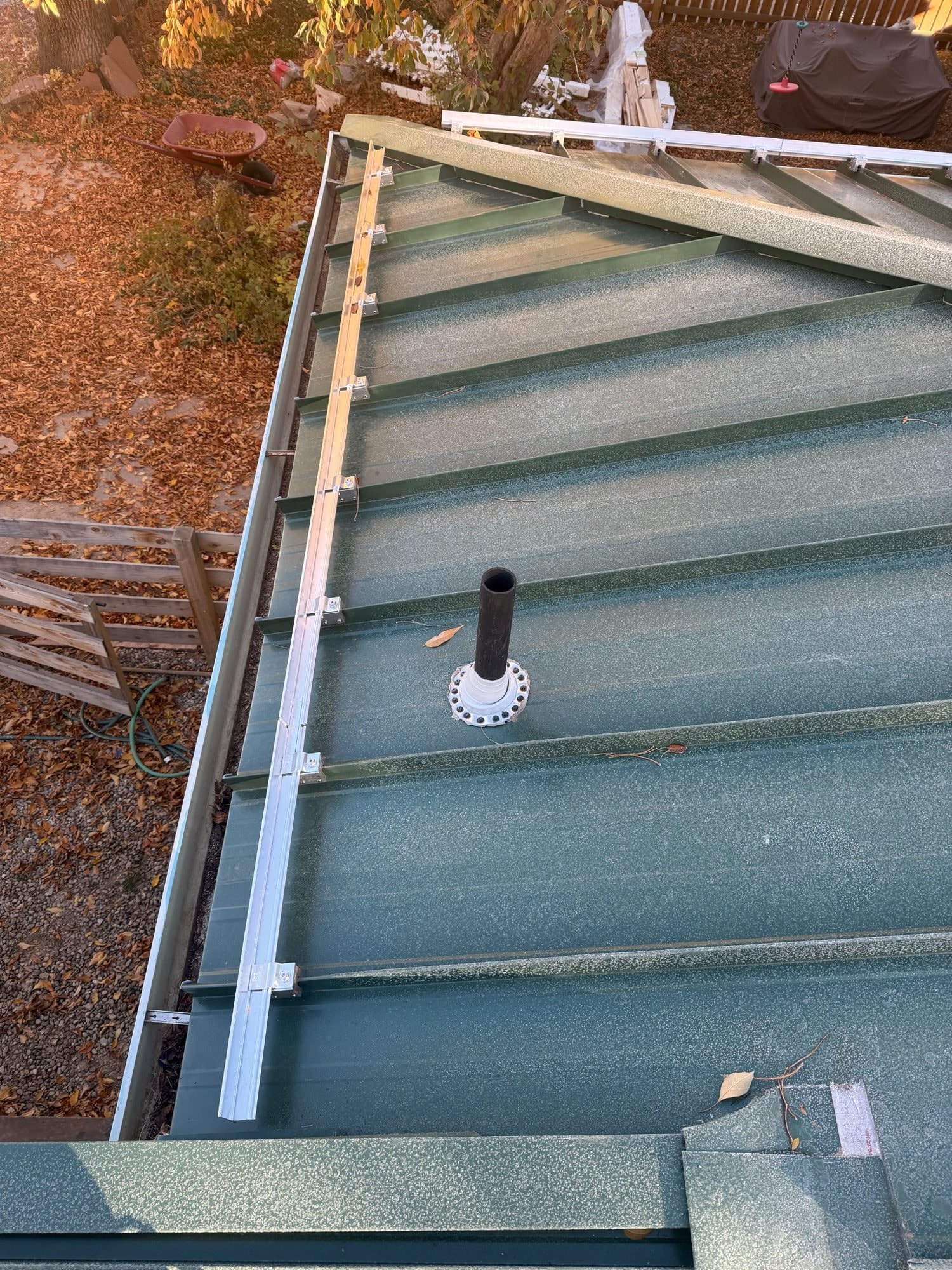 Green standing-seam metal roof installed on a residential home