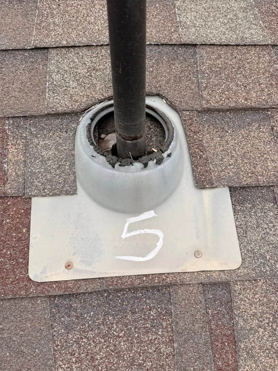 Open separation at a roof pipe boot in a Drennen inspection photograph.